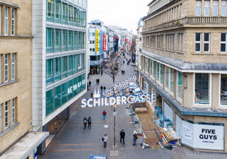 Blick in die fast menschenleere Fußgängerzone in Köln, halbe Höhe von der Drohne aus. Schriftzug „city shopping Schildergasse